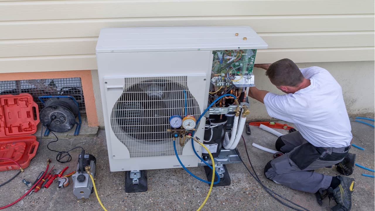 Man repairs a heat pump