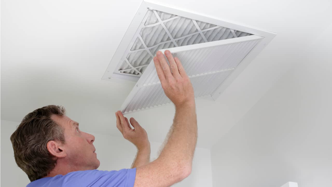 Man replaces HVAC air filter