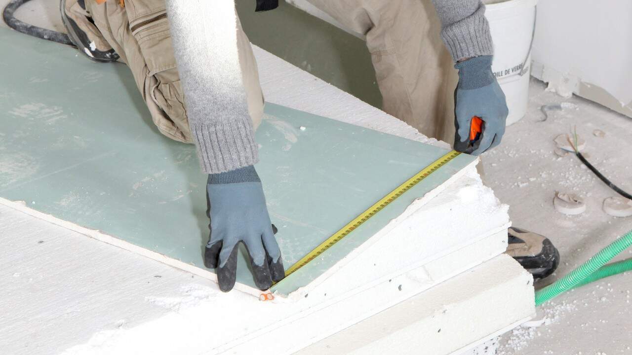 Man installs basement ceiling insulation